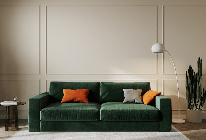 Sala de estar com parede neutra e sofá verde escuro. 